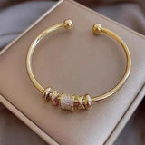 Adjustable bracelet with gold charms